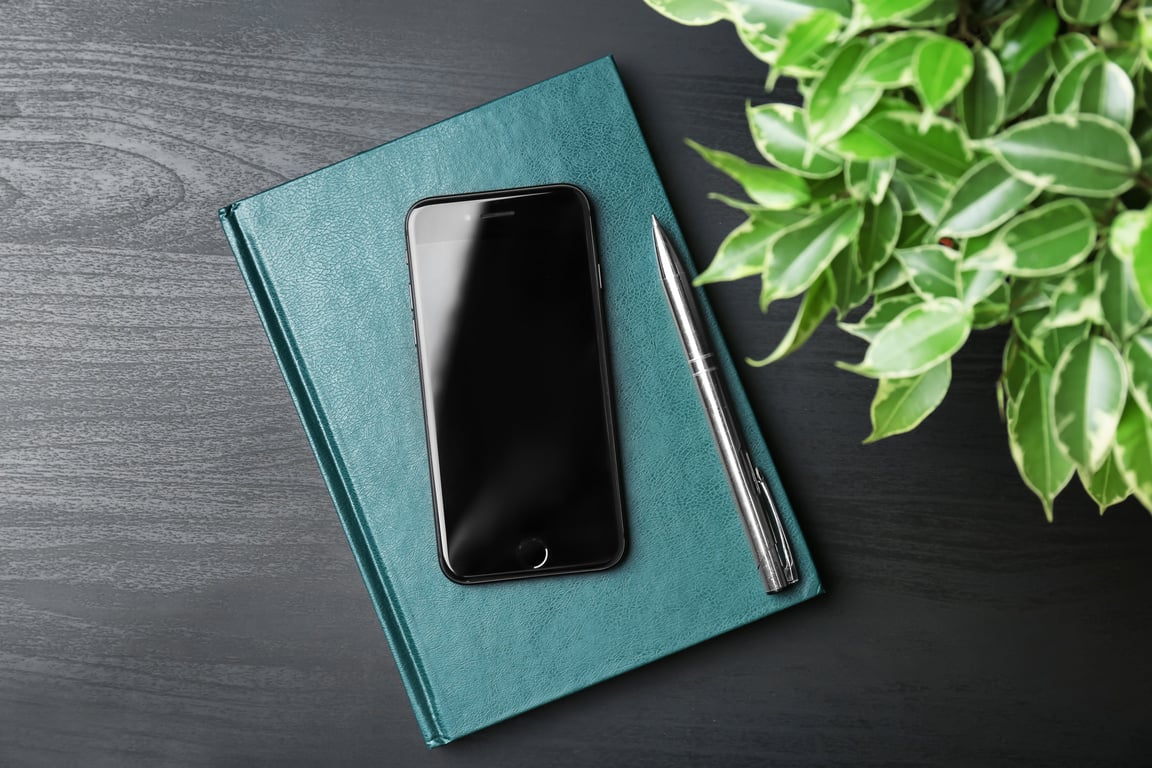 Mobile Phone, Pen, and Notebook on Table